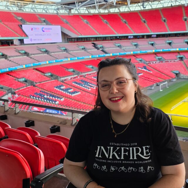 Added a new line to our achievements: worked at Wembley Stadium with @inkfirelimited
BASE Conference 2025 successfully wrapped!VD:
Photo 1: Imali sitting with her back to an empty Wembley Stadium. She is smiling at the camera and wearing an Inkfire branded t-shirt.
Photo 2: Imali, a white woman with brown hair and pink glasses, next to Gillian, a white woman with light brown hair and sunglasses. Both are smiling at the camera with Wembley in the background along with the display board.
Photo 3: A close up of the display board, which has various logos for the sponsors of the conference, including BASE. |