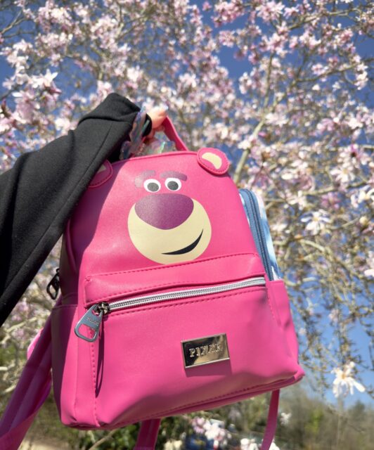 'Well, hello there, I'm Lotso-Huggin' bear, but please call me Lotso' 🍓This Disney girl is absolutely over-the-moon with this super cute, Lotso backpack from the Pixar range! I'm particularly thrilled with the size of the side pockets - as they're big enough for me to stash my epi-pens in an easy reach place.Who's your favourite Toy Story character?VD: A pink backpack, with a Lotso-Huggin bear face and 3D ears. I am holding it against a background of pink blossom on a tree.