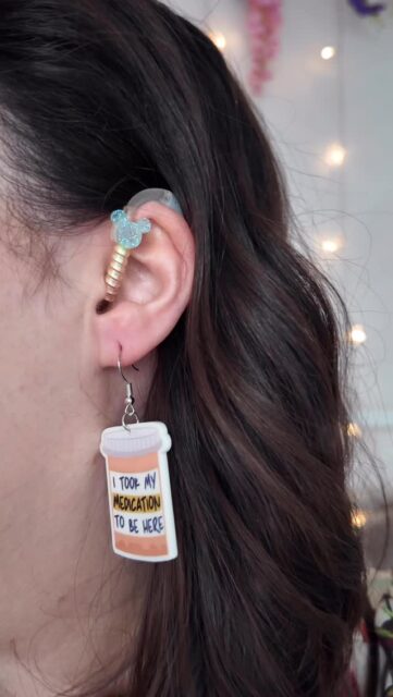 This is your sign to wear the earrings if you love them✨ Follow for more like thisFeaturing my gorgeous hearing aid charms from @charmed.sense.accessories (yes, fun earrings do work with hearing aid accessories!) and various whimsy earrings from @flyingtiger @etsyuk and charity shop haulsVD: A white woman with brown shoulder length hair, trying on earrings of different sizes, including heart hoops, mini cups of tea and pillpots that say ‘I took my medication to be here’.(Hashtags)
#Whimsy #EarringCollections #WhimsicalDress #DopamineDress #ChronicIllness