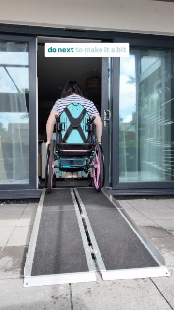 Any ideas for what you’d do next? I’m thinking of adding fairylights and some flowers to bring it to life 😍Pergola purchased by me from @aosomuk #AosomUK
Ramps from @careco_mobility (Ad PR gifted)
Outdoor mini house from @bm_storesVD: A white woman with brown hair in a wheelchair, using a portable ramp, outside seating area with dark grey cushions and showing you around a garden space.