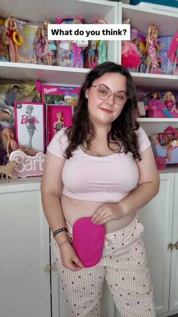 I've collected over 100+ Barbies throughout my life, but I've never seen one that reflects my experience of living with a stoma. This World Ostomy Day, I'm calling on Mattel to change that 💖VD: A wall of Barbies in Imali's flat. She keeps showing different dolls up close in their boxes and then at the end it cuts to her, stood in front of her Barbies with her stoma on show. She has a pink bag cover on and a light pink top.