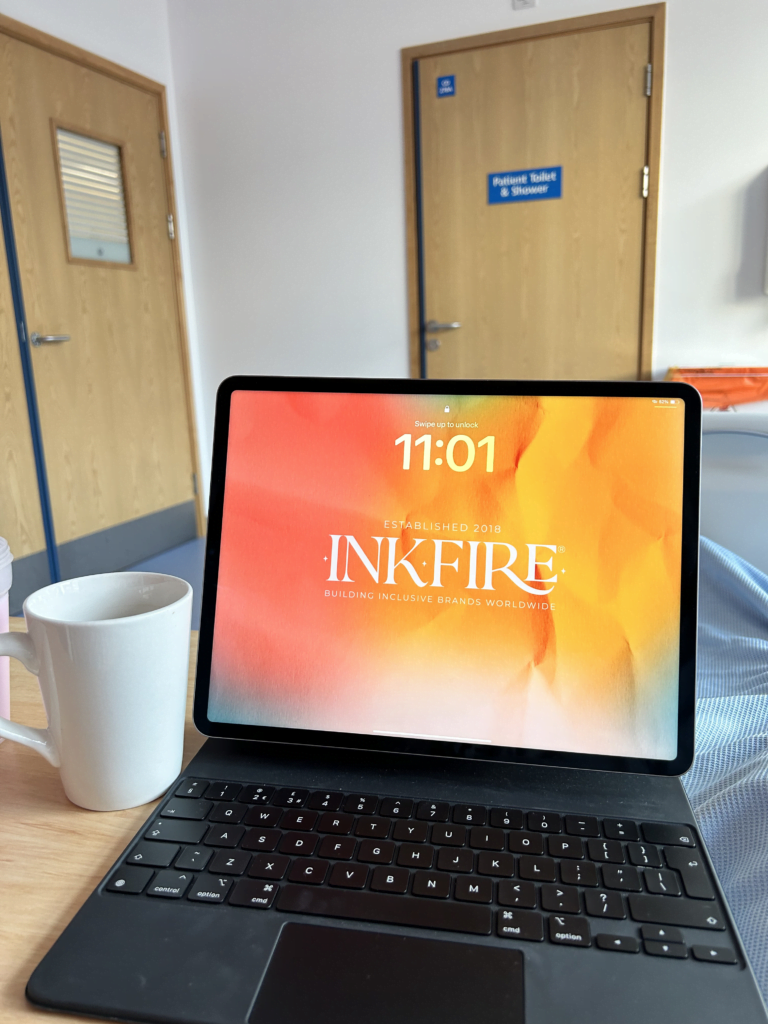 Ipad sat on an over the bed table in hospital, with a cup of tea next to it. Working from hospital with a chronic illness